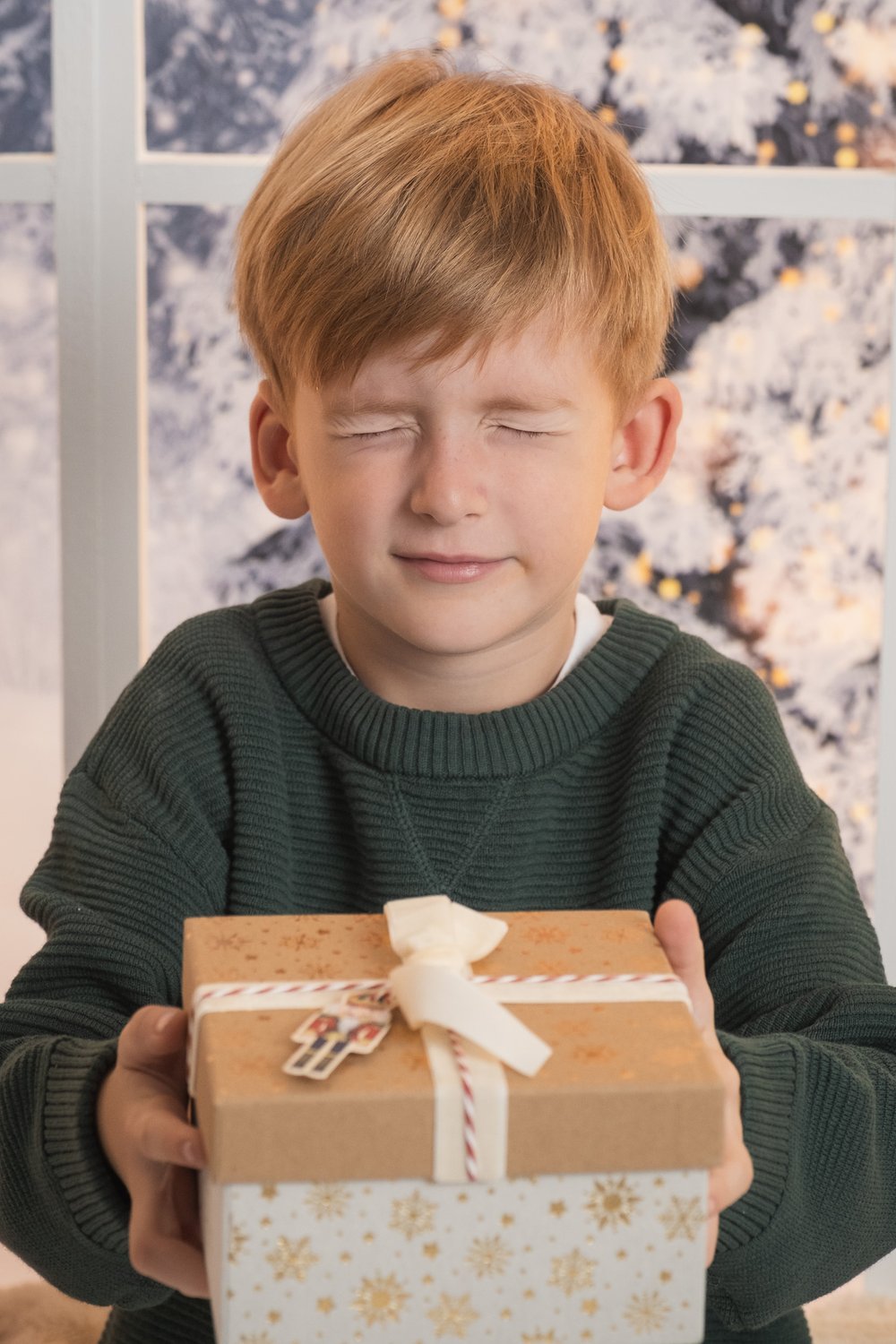 Niño con un regalo de Navidad en una sesión de fotos navideña en Alicante